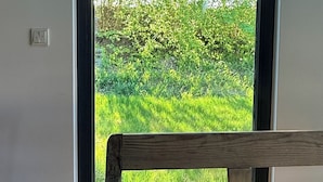 Ein Zimmer mit großem Fenster, einer hölzernen Bank und einer Steckdose.