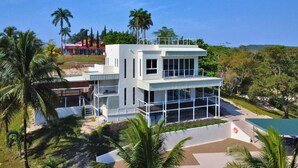 Un edificio moderno de dos pisos con ventanas amplias, techo plano y balcón.
