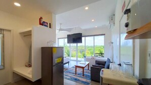 Una cocina moderna con refrigerador empotrado, un comedor con mesa y sillas, un ventanal con vistas y un ventilador de techo.