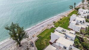 A coastal hotel with ocean views, a sandy beach, and a well-maintained lawn. - Gulf View Condo - Beach Access - Rooftop Deck (Englewood)