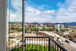 A cityscape with mountains in the background, a construction site, and a clear sky. - Stylish 2-Bedroom, 2-Bath Salt Lake City Apartment with Balcony (Salt Lake City)