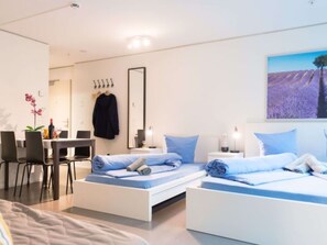 Et moderne hotelværelse med to senge, et skrivebord og en stol.