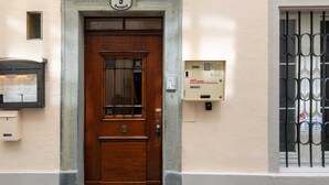 Una puerta de madera con un cartel con número, un buzón y un buzón de seguridad en la pared.