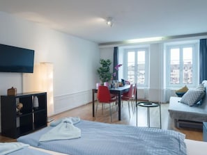 Una habitación de hotel moderna con una cama, un escritorio, una silla y un sofá.