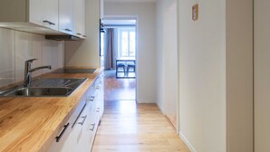 Cocina moderna con encimera de madera, pileta de acero inoxidable y alacenas.