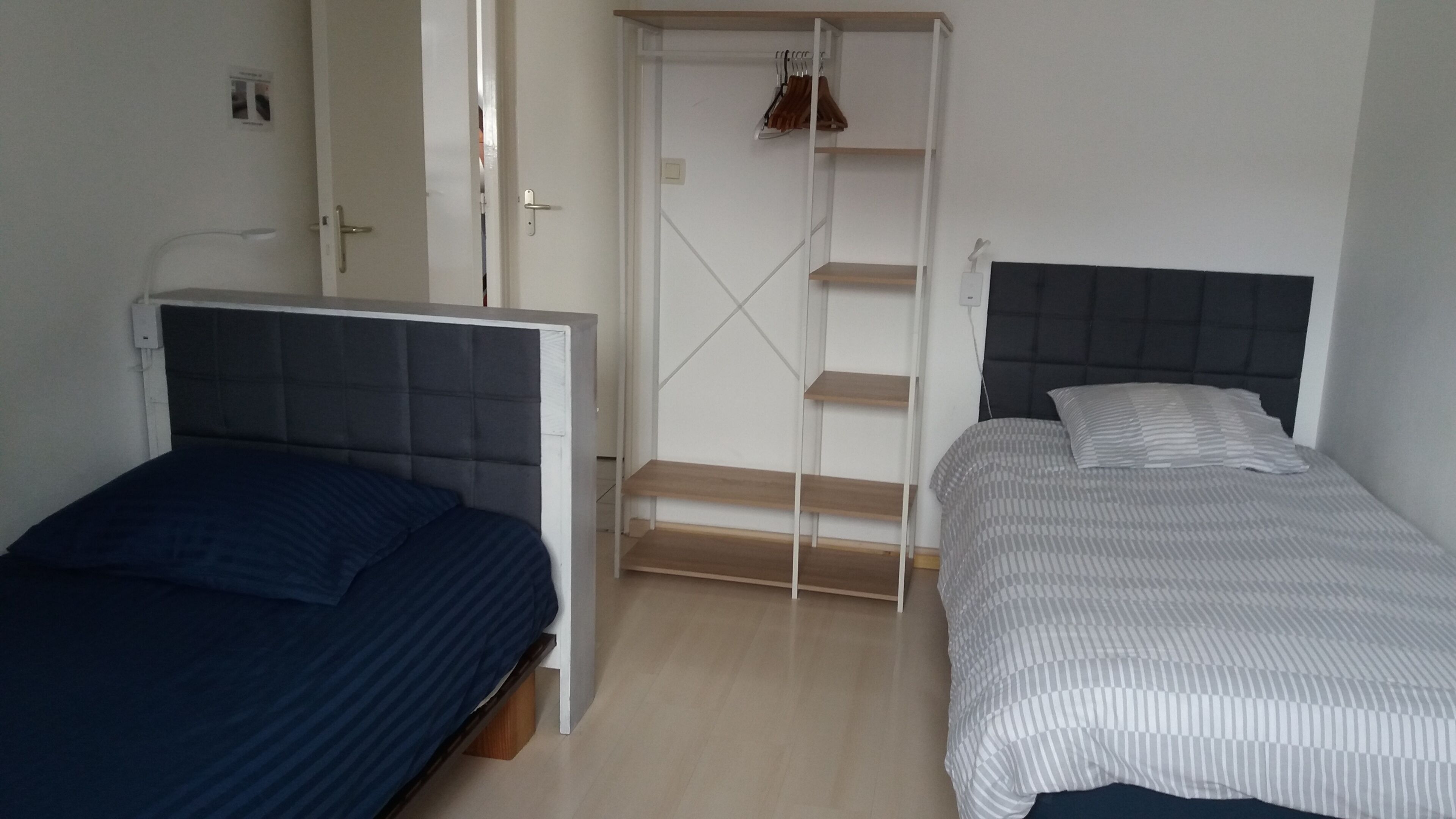 Un dormitorio con dos camas, un armario y un tramo de escaleras.