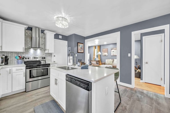 A modern kitchen with stainless steel appliances, a dishwasher, and a central island.