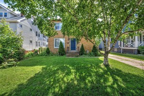 A two-story house with a front yard, a blue door, and a small front porch. - Pet-Friendly Home - Sleeps 6 - Walkable Lakewood (Lakewood)