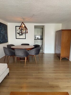 A modern living room with a wooden dining table, grey upholstered chairs, a hanging light fixture, a painting, and a kitchen visible through an open doorway. - WorldCup2026 7km + Parking + Security 24/7 Big Apartment near Frida Kahlo house. (Ciudad de México)