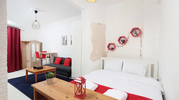 Een moderne hotelkamer met een bed, een houten tafel, een rode lantaarn en een klok aan de muur.