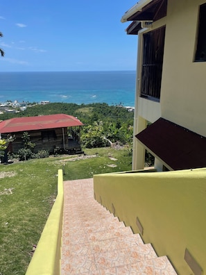 A staircase leading to a building with a view of the ocean.