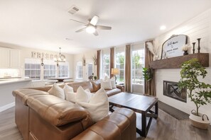 Ein geräumiges Wohnzimmer mit einer Ledersofa, einem Holztisch und einem Kamin.