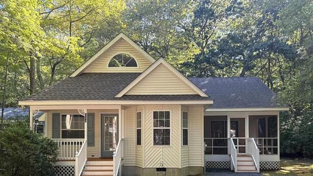 A two-story house with a front porch, a small staircase, and a garage.