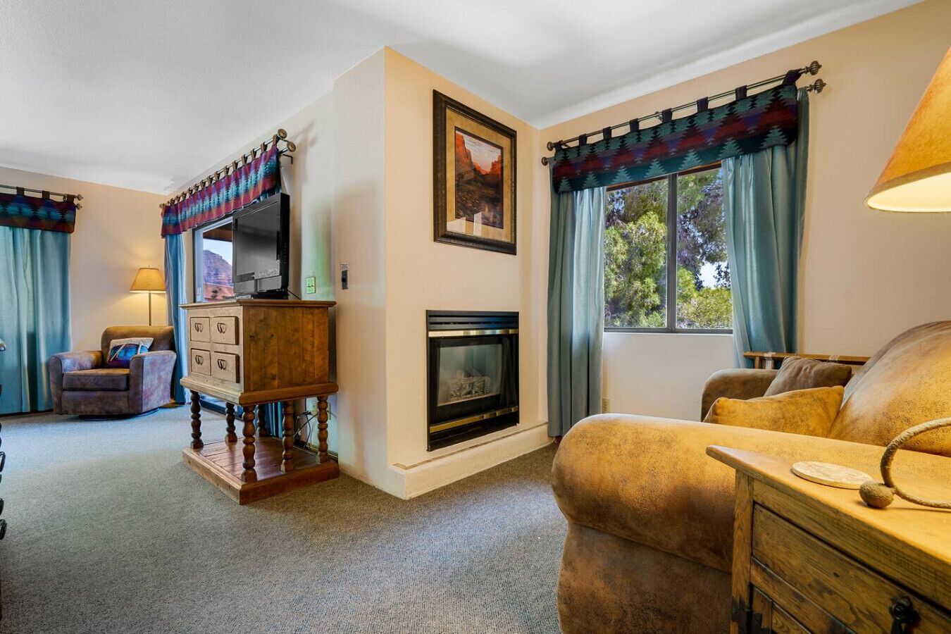 A living room with a fireplace, a television, a sofa, and a wooden cabinet.