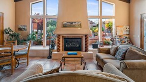A spacious living room with a fireplace, large windows, and a cozy seating area.