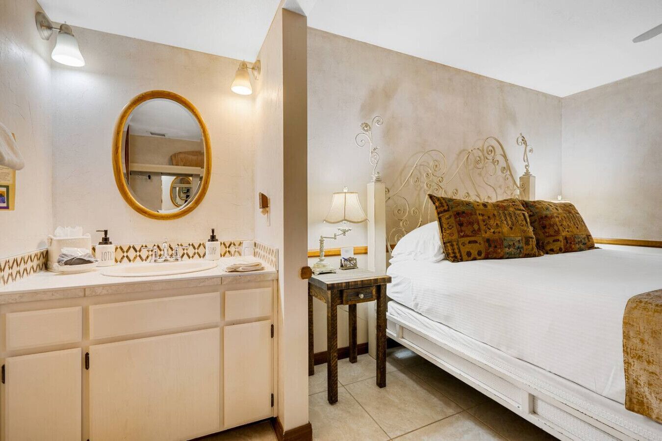 Une chambre à coucher avec un lit, une table de chevet, une lampe et un miroir.