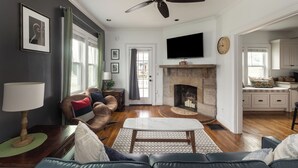 Una sala de estar con chimenea, televisor y comedor.