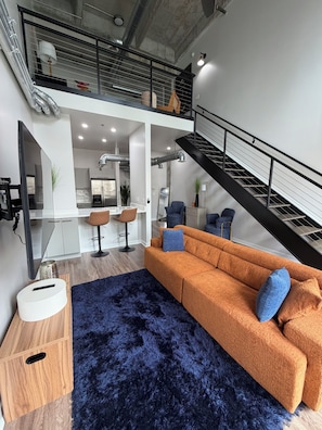 Ein modernes Wohnzimmer mit Sofa, Couchtisch und Treppe.