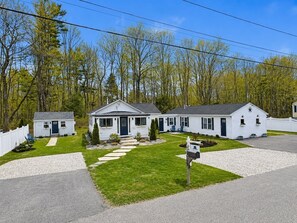 A row of white single-story houses with a front lawn, a mailbox, and a white picket fence. - King Suite Getaway, Downtown Ogunquit. Walk to Beach, Shops & Dining! (Ogunquit)
