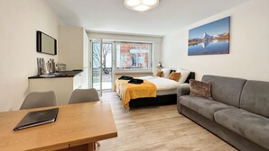 A modern room with a bed, a sofa, a dining table, and a large window. - Apartment  by Interhome (Zermatt)