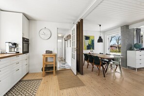 Et moderne køkken med hvide skabe, en træbordplade og en indbygget ovn.