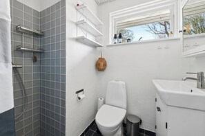 A bathroom with a shower, toilet, sink, and window. - Cozy holiday home near the beach and Gilleleje (Gilleleje)