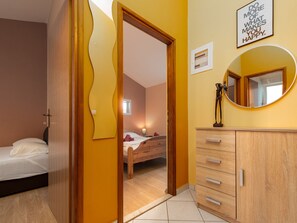 A room with a bed, a bedside table with a lamp, a mirror, and a wall with a motivational quote. - Apartment Julia A1,  2+2 by Interhome (Biograd na Moru)