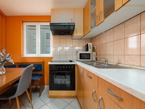 A compact kitchen with a stove, oven, microwave, and sink. - Apartment Julia A1,  2+2 by Interhome (Biograd na Moru)