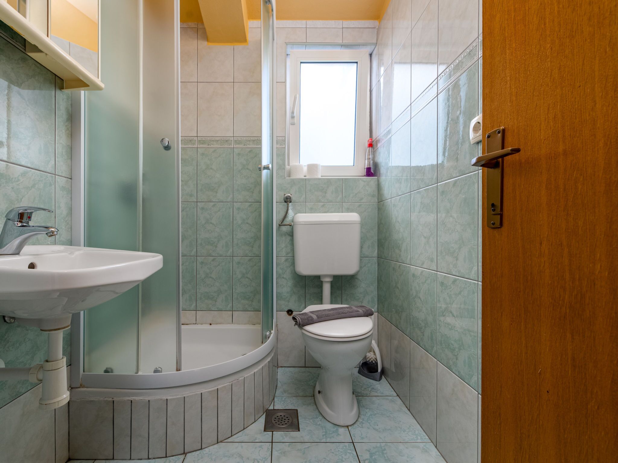 Un baño con ducha, inodoro y lavabo.