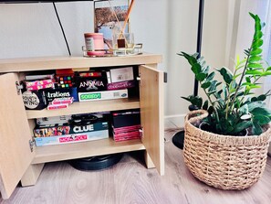 Ein Regal aus Holz mit Brettspielen, einer Kerze und einem gerahmten Bild.