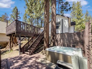 A hot tub, wooden deck, and a small building with a staircase leading up to a deck. - Eagle Point Walk to Lake & Hot Tub (Big Bear Lake)