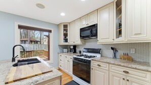 A kitchen with white cabinets, a built-in microwave, a gas stove, and a sink. - 3-bedroom Comfy Townhome, less than 10 min from the Battery, Bring the Family (Marietta)