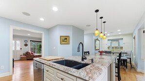 A kitchen with a large island, white cabinetry, and a pendant light fixture. - 3-bedroom Comfy Townhome, less than 10 min from the Battery, Bring the Family (Marietta)
