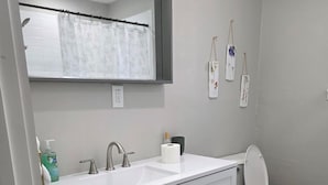 Ein Badezimmer mit Waschbecken, Spiegel und Toilette.