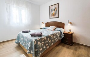 A bedroom with a bed, nightstands, a painting, and a window with sheer curtains. - Lovely home in Totalan with WiFi (Totalan)