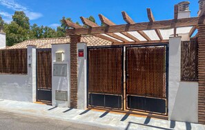 Ein begrenzter Zugang mit einem hölzernen Pergola, einer Sicherheitsbegehung und einem Metalltor.