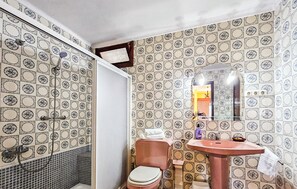 A bathroom with patterned tiles, a toilet, a sink, and a shower. - Stunning home in Prado del Rey (prado del Rey)