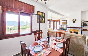 A dining area with a table set for four, a sofa, a TV, and a fireplace. - Stunning home in Prado del Rey (prado del Rey)