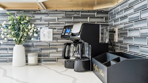 Une cuisine moderne équipée d’une machine à café, d’un vase avec des fleurs et d’un coin café.