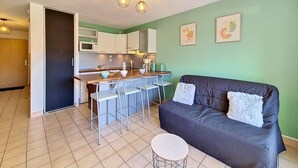 A compact living space with a kitchenette, a sofa, and a dining area. - Carnac - 2-room apartment - 30m² (CARNAC)