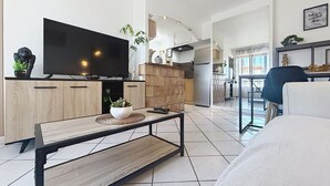 Una sala de estar moderna con un televisor de pantalla plana, una mesa de centro de madera y un sofá.
