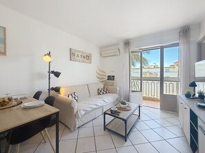 Ein modernes Wohnzimmer mit einer Couch, einem Esstisch und einem Balkon mit Blick.