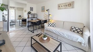 Una sala de estar moderna con sofá, mesa de centro y comedor.