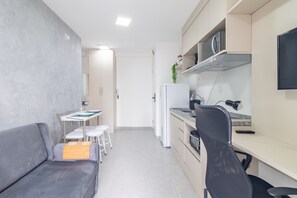 A compact living space with a kitchenette, a dining area, and a seating area. - Apt 3p / 1br - Cardeal (São Paulo)