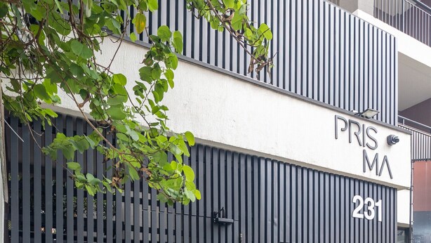 Un edificio moderno con un letrero que dice "PRISMA 231" y una puerta de seguridad.
