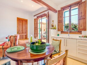 Un coin repas avec une table en bois, des chaises et un vase vert servant de centre de table.