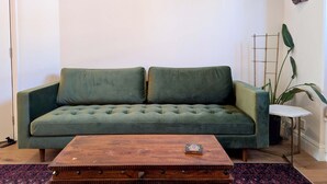 A green sofa with a wooden coffee table in front. - Cosy Bright 2-bed House in Earlsfield (London)