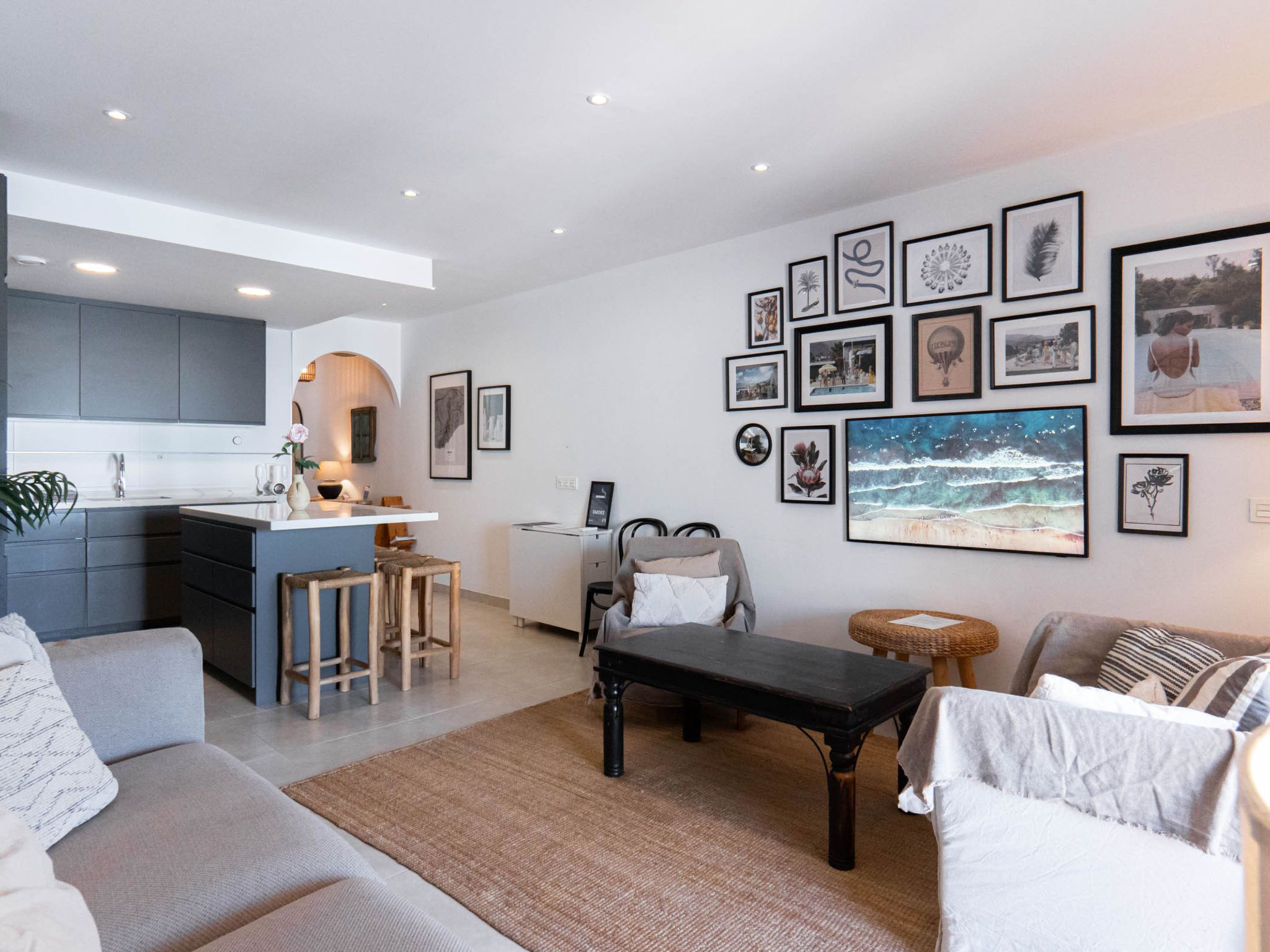 Una sala de estar moderna con un sofá, una mesa de centro y un comedor con una cocina al fondo.