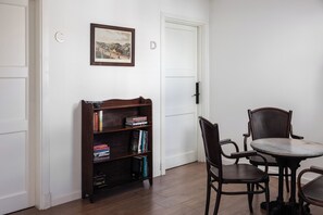 Una habitació amb una biblioteca, una taula de menjador i caires.