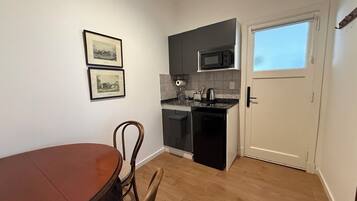 Suite Deluxe, patio, vistas a la ciudad | Cocina privada | Frigorífico pequeño, microondas, placa de cocina y utensilios de cocina